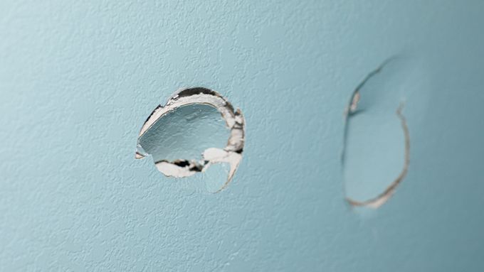 A wall with a hole in it that needs to be fixed.