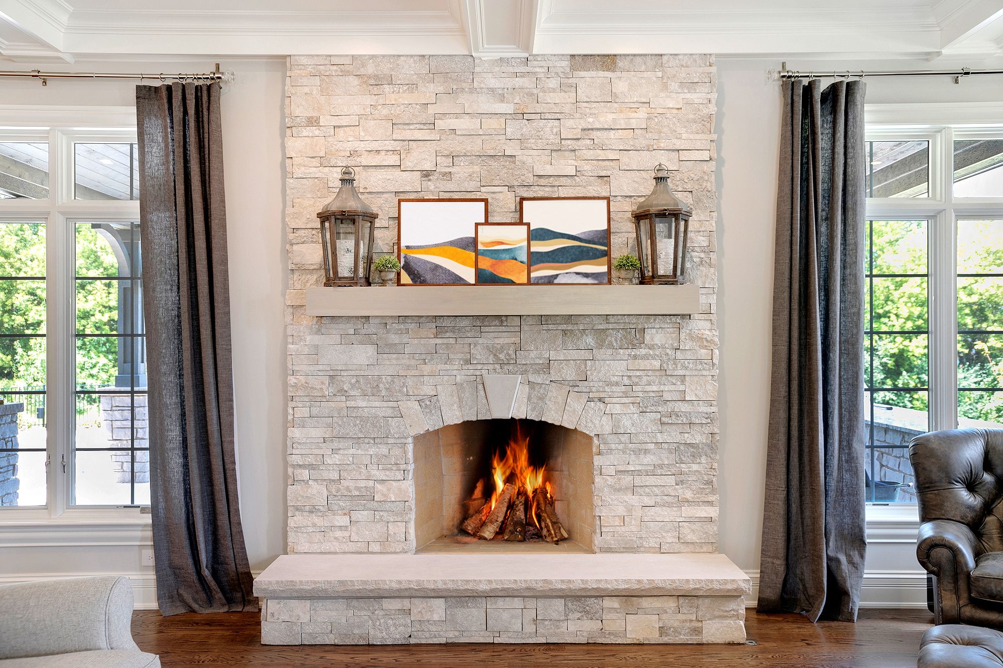 A stone fireplace with a mantel above it holding framed photos.