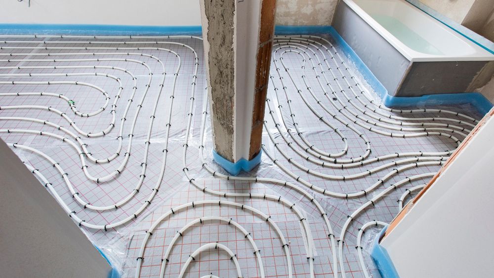 White piping wrapped around a room that makes up a radiant heating system.