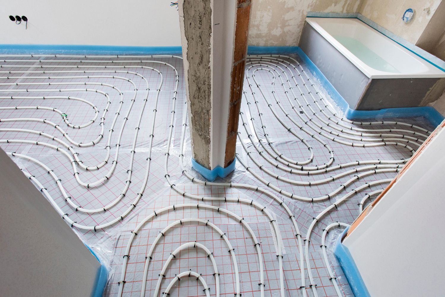 White piping wrapped around a room that makes up a radiant heating system.