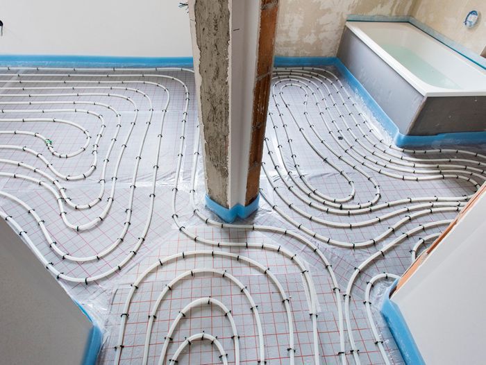 White piping wrapped around a room that makes up a radiant heating system.