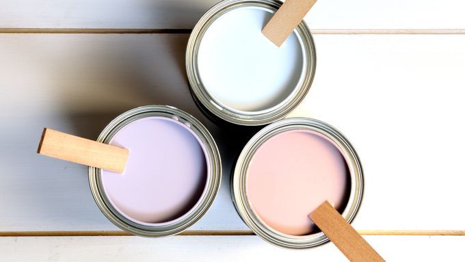 Cans of paint with mixing sticks.