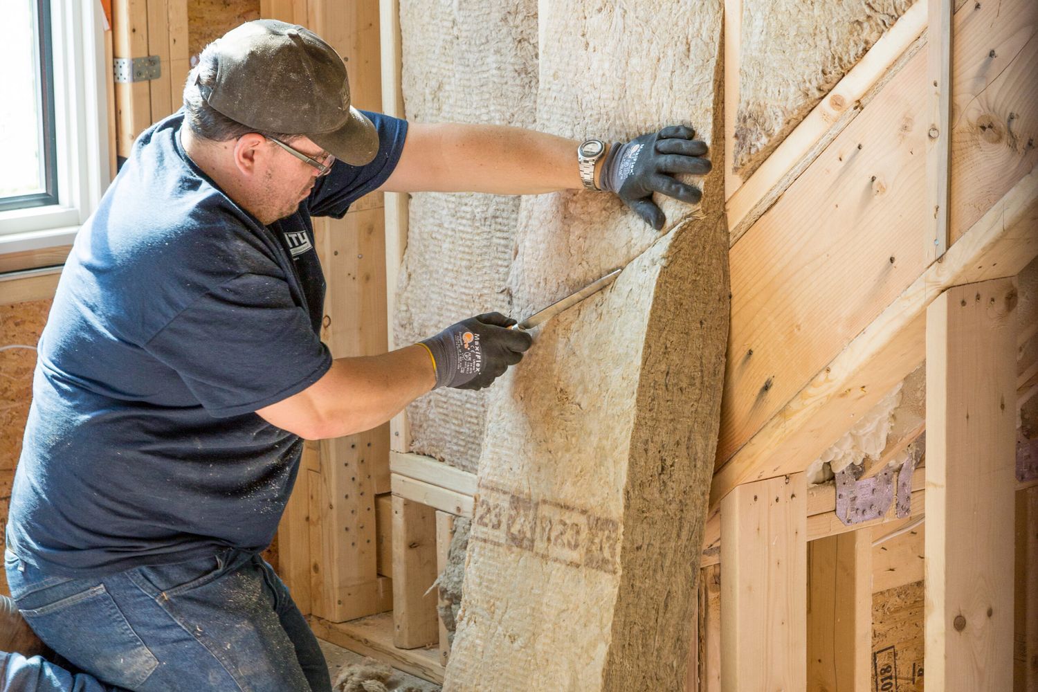 Man installing insulation in a home.