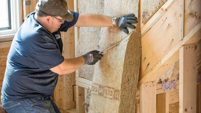 Man installing insulation in a home.