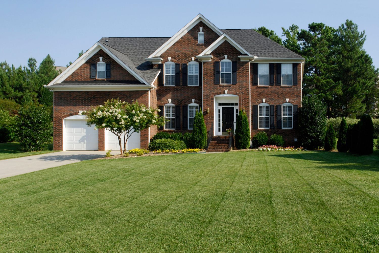 An organic lawn inf front of a brown brick home.