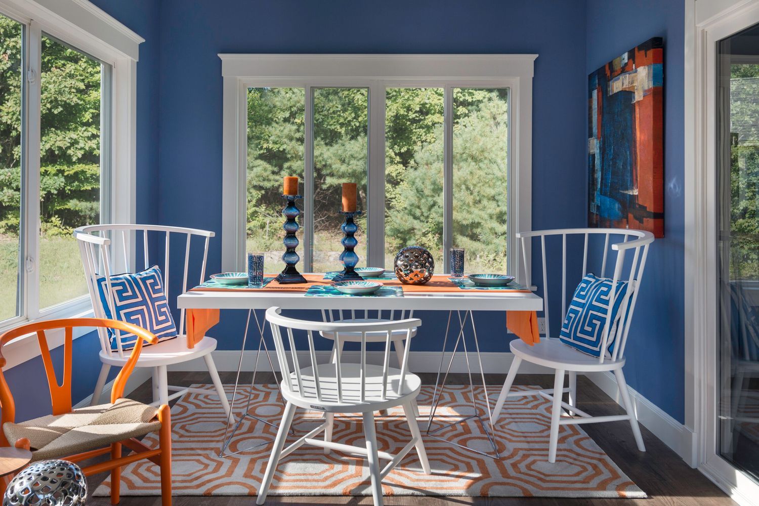 A sitting room with large windows and a blue-orange color scheme.