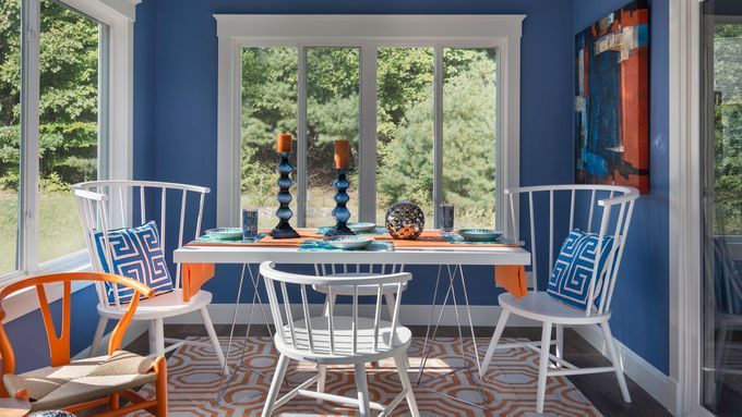 A sitting room with large windows and a blue-orange color scheme.