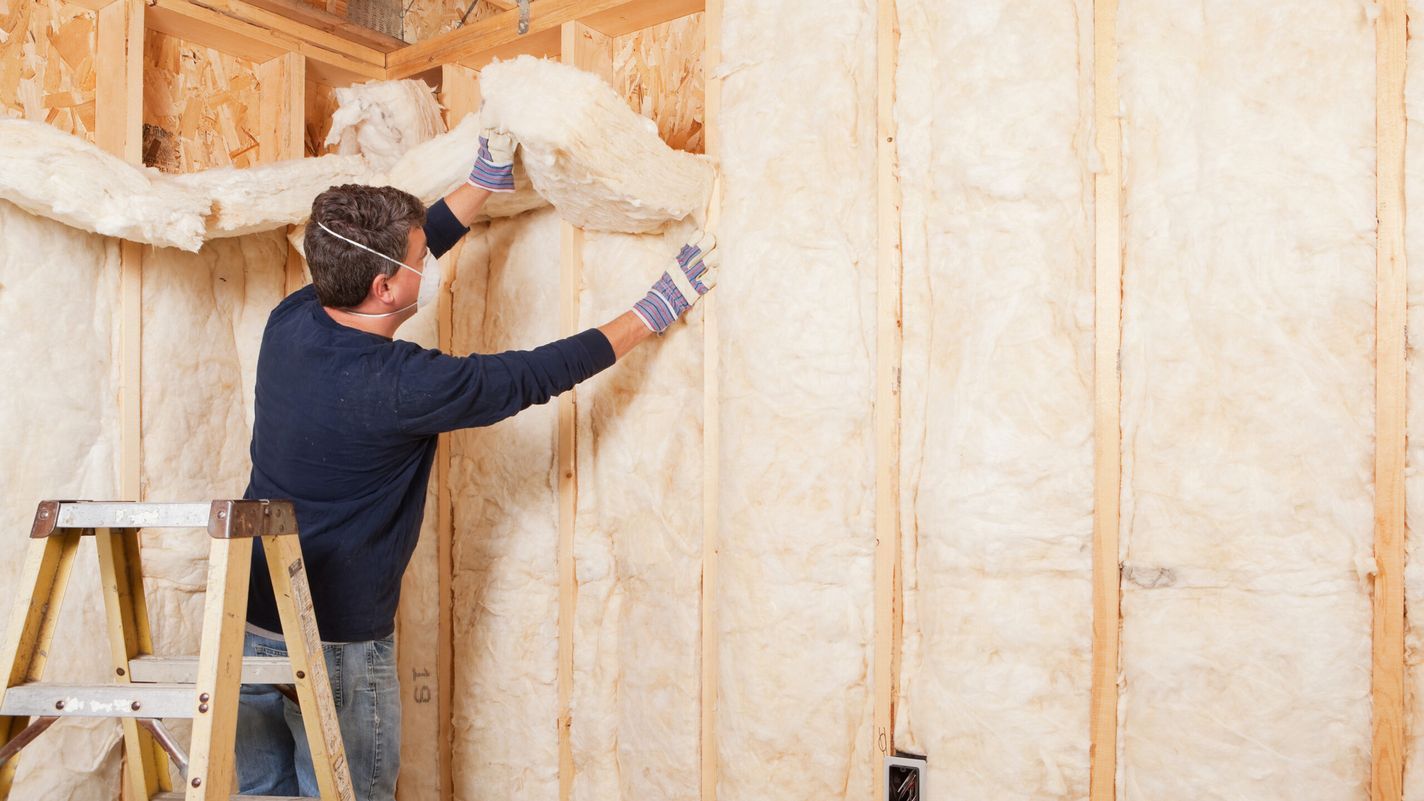 Man installing insulation i a wall.