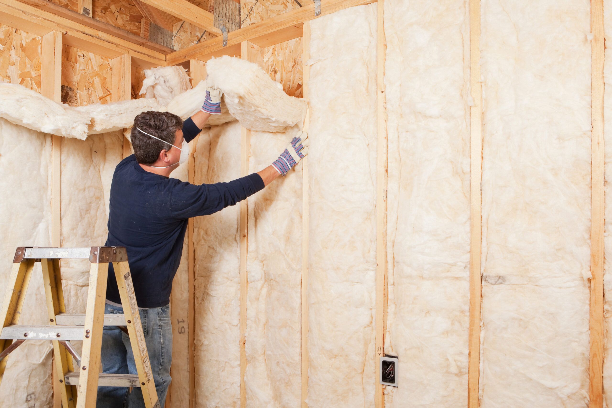 Man installing insulation i a wall.