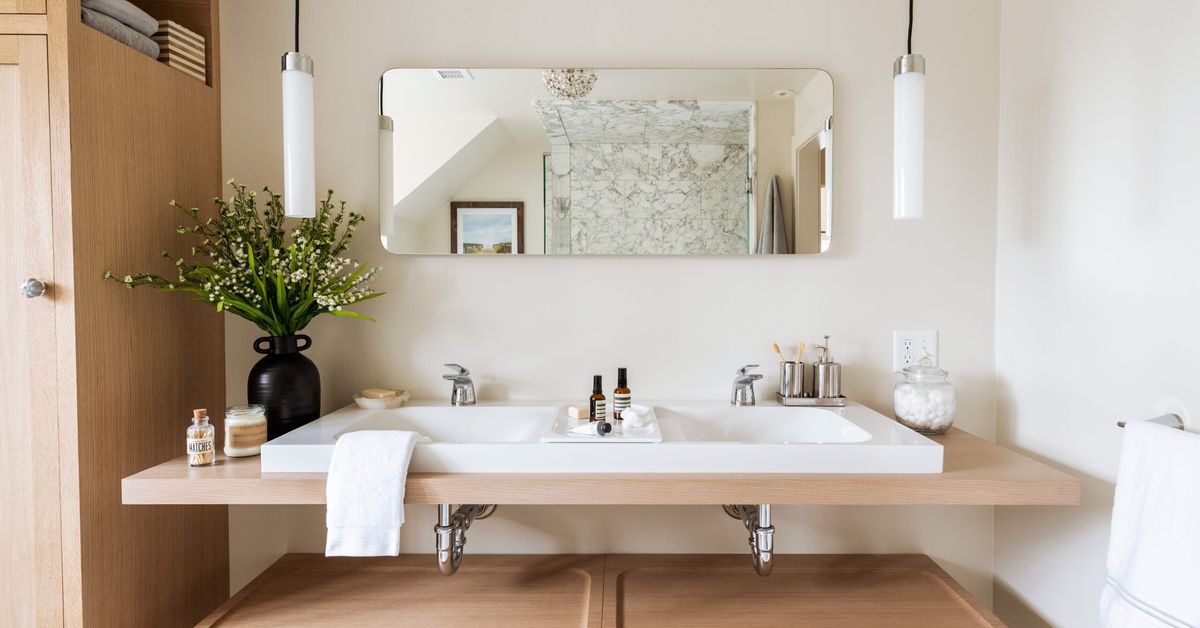 A remodeled bathroom with two sinks and a mirror.