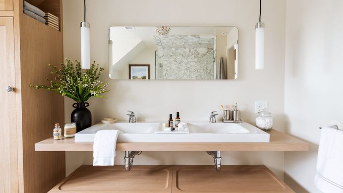 A remodeled bathroom with two sinks and a mirror.