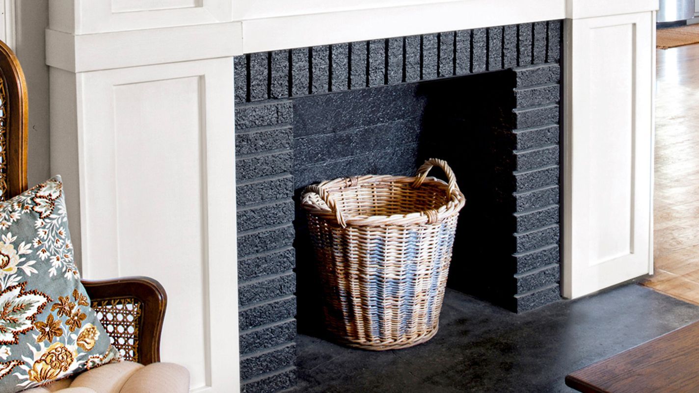 Finished Product, White wood trim brightens the fireplace, which is accented by a rustic mantelshelf; a black-painted firebox adds depth.