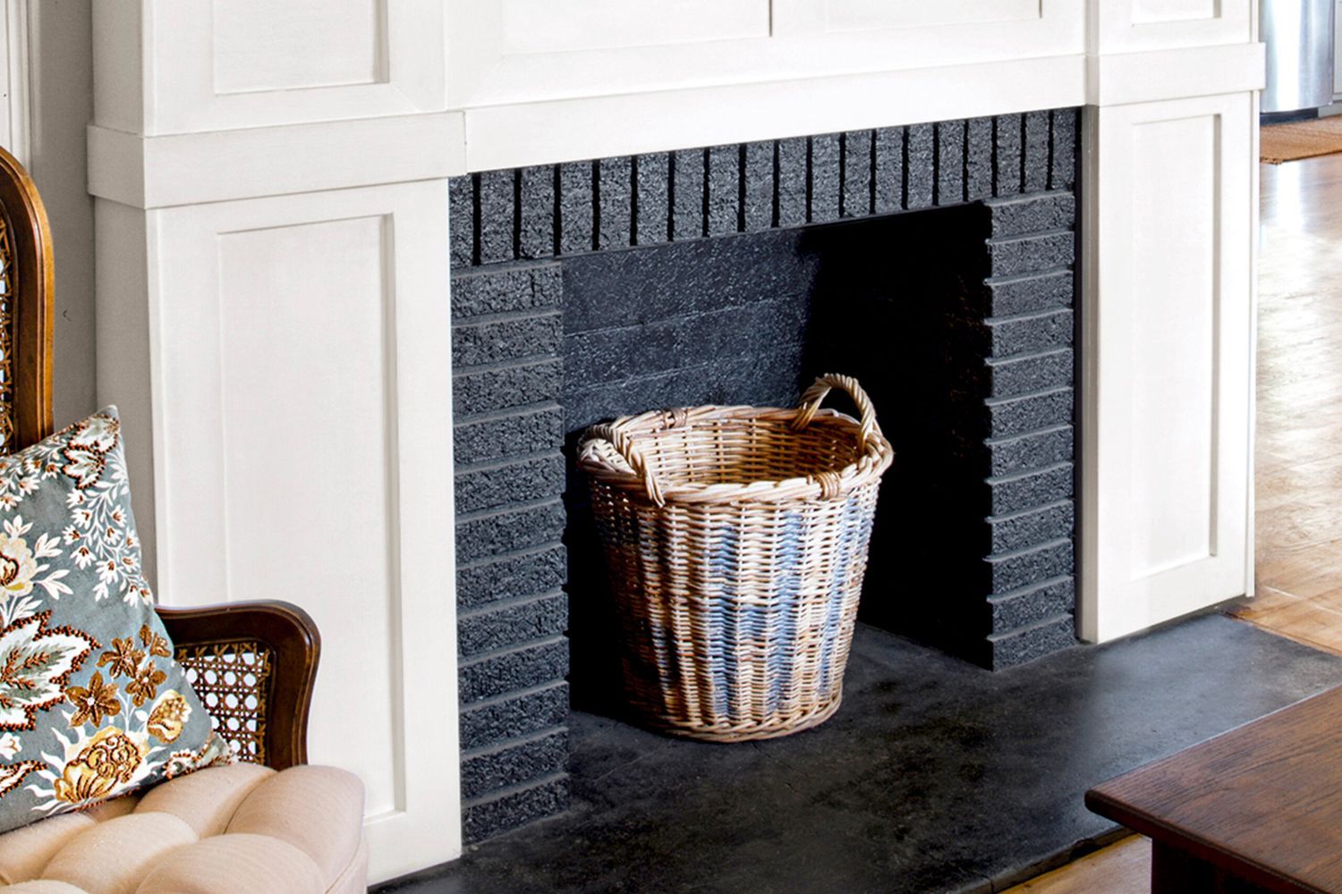 Finished Product, White wood trim brightens the fireplace, which is accented by a rustic mantelshelf; a black-painted firebox adds depth.
