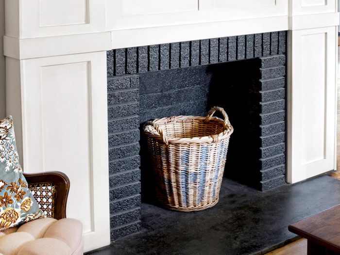 Finished Product, White wood trim brightens the fireplace, which is accented by a rustic mantelshelf; a black-painted firebox adds depth.