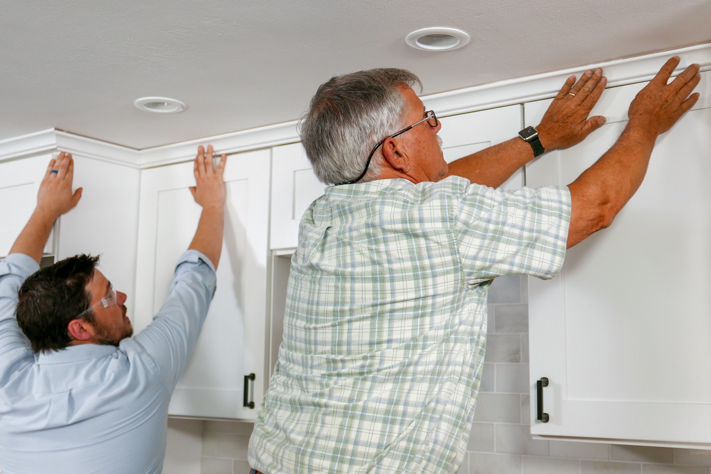 Tom Silva placing crown molding in kitchen