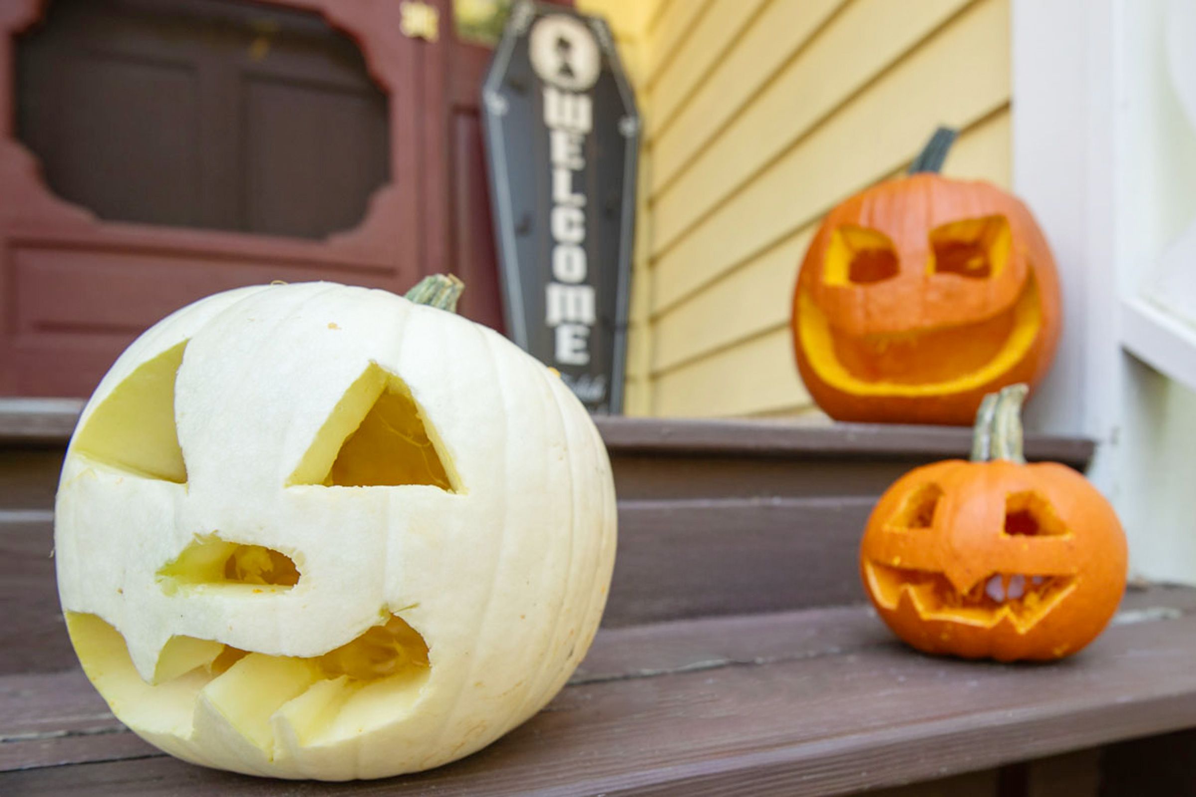 jack o lanterns sitting on the front steps leading up to a house