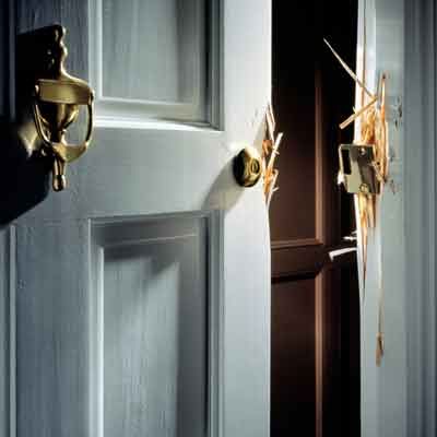 A door that has been broken into in a house with poor security.