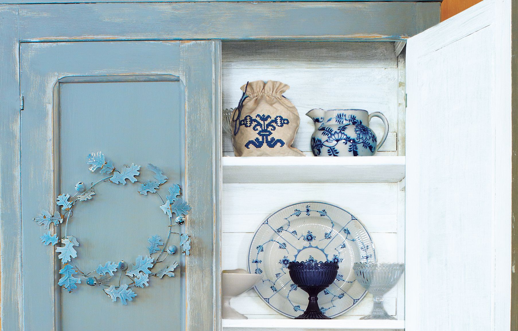 A faux aged cabinet with dishes within.