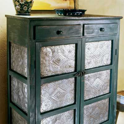 A wooden dresser with tin punching pieces in it.