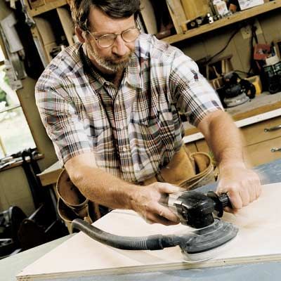 Man using orbit sander.