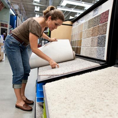 a woman searching through carpet samples