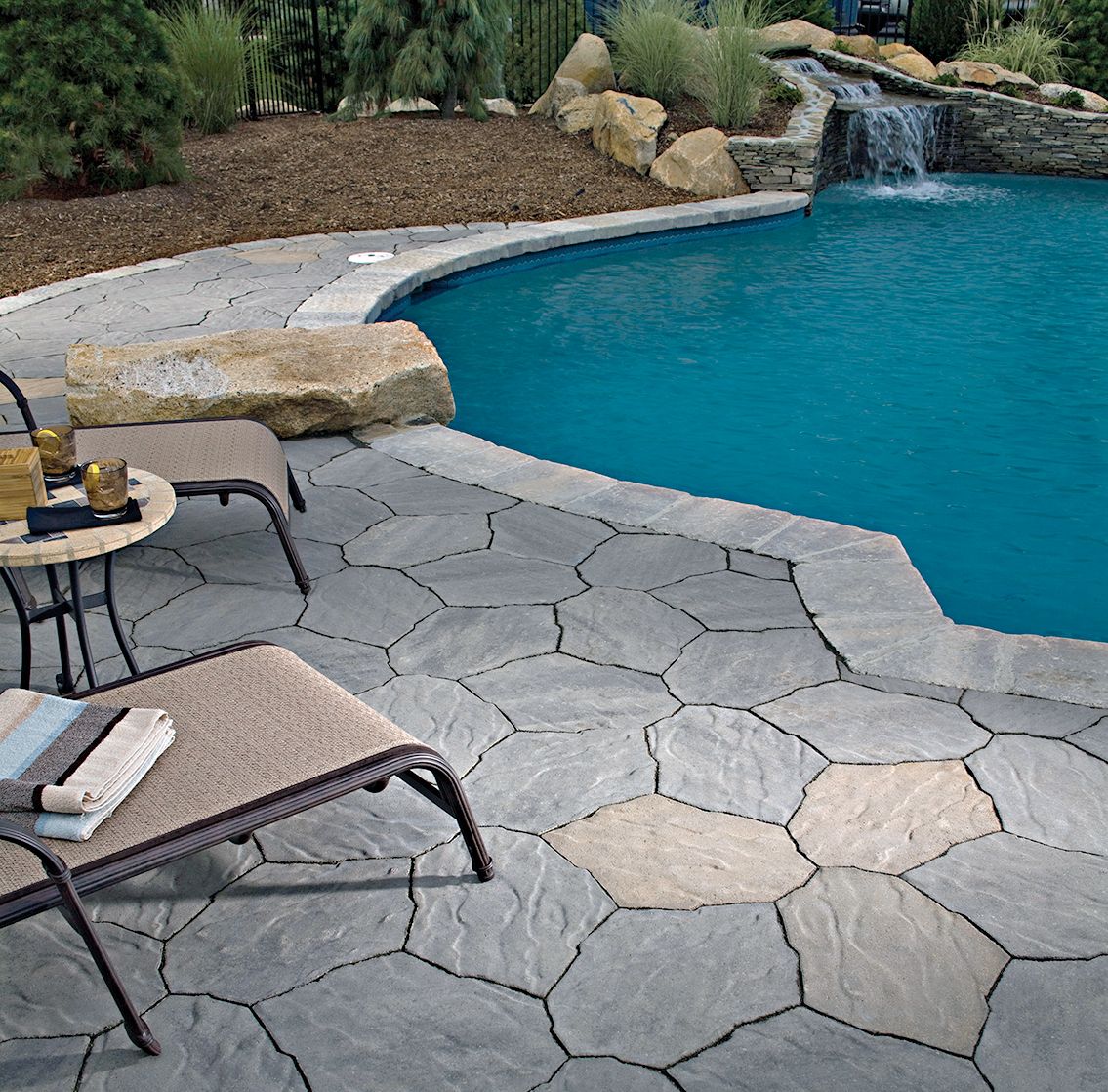 A pool surround built from concrete pavers.