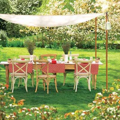 Wooden table and chairs in the middle of a garden. 