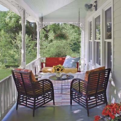 A farmhouse porch in front of a house.