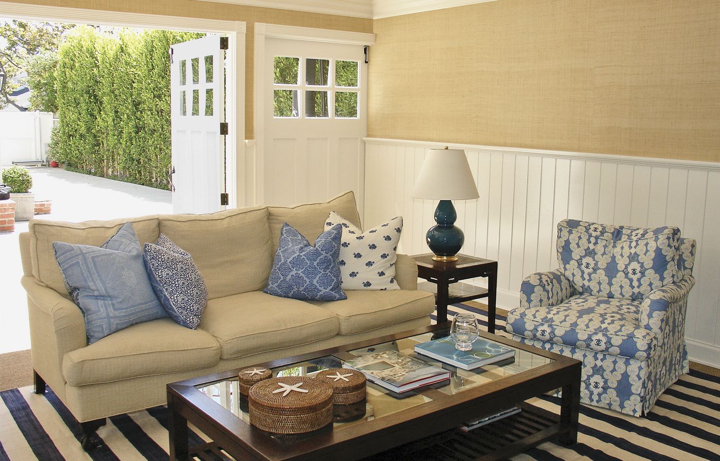 a converted garage to a rec room with open doors, a couch.