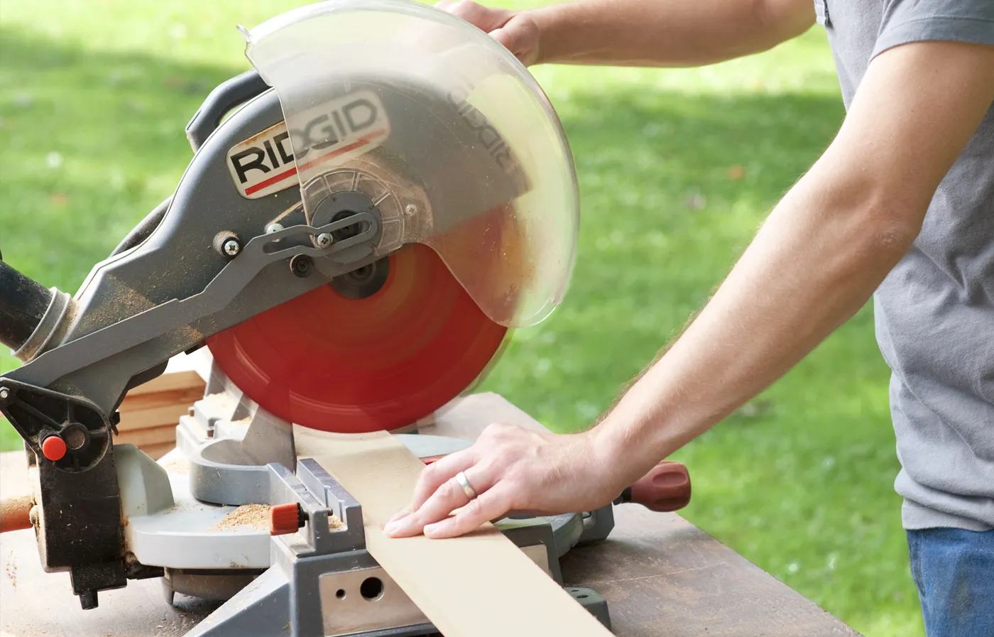 A person using a miter saw to cut the pieces of wood to size.