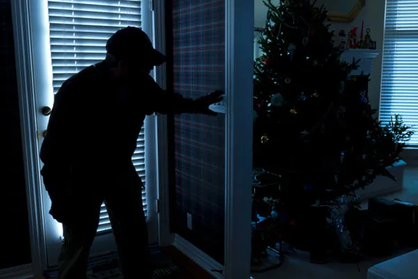 A man breaking into a home during the holiday season.