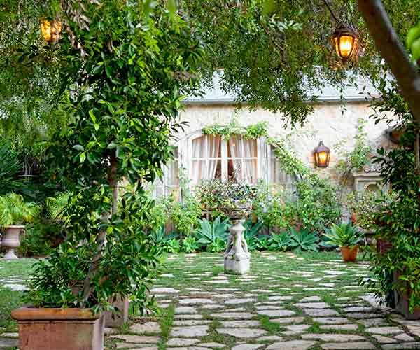 A beautiful backyard in the summer illuminated by lights.