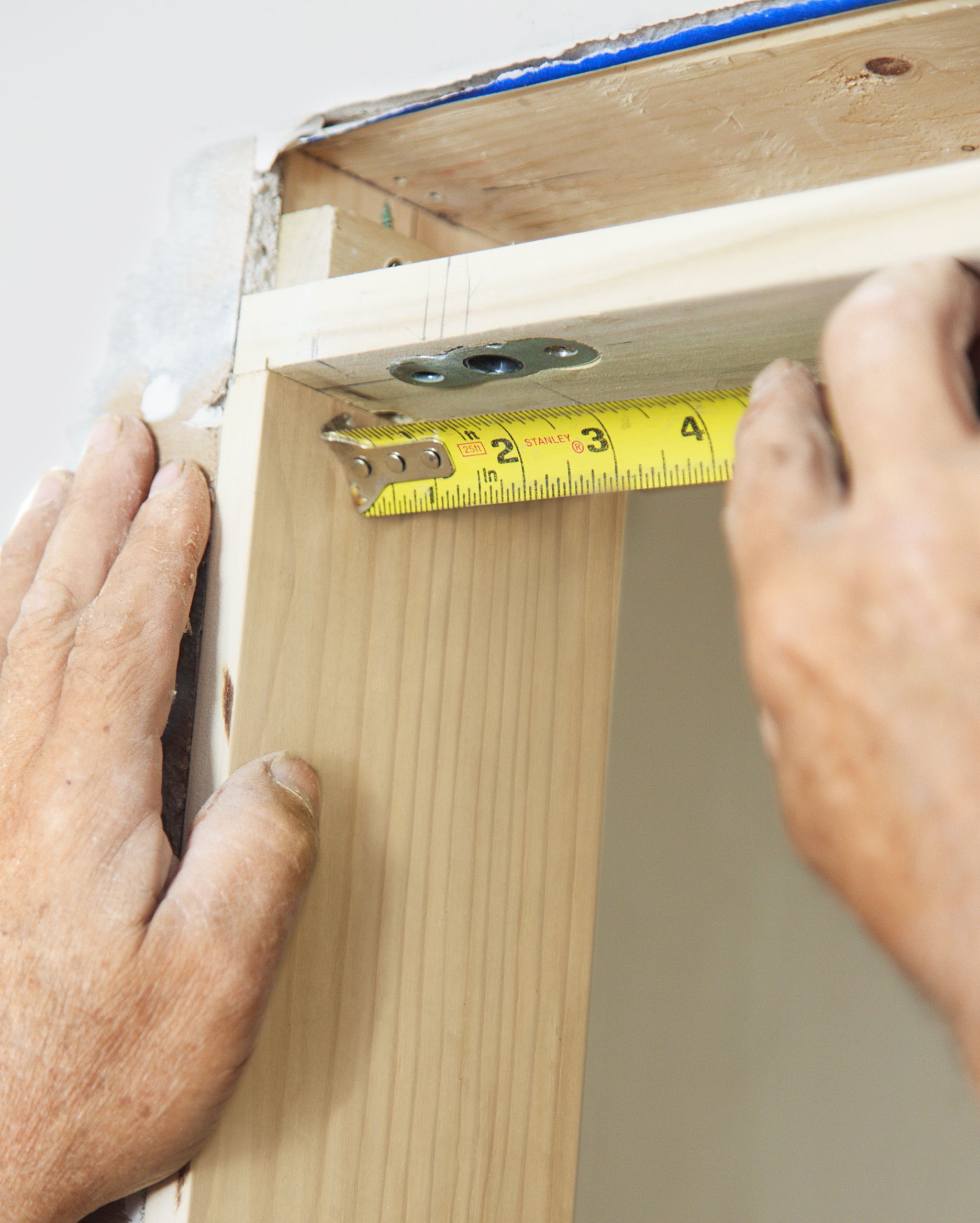 A man measuring a door frame.