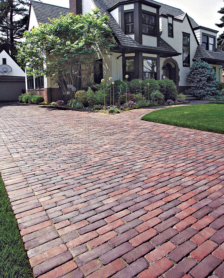 A home driveway made from concrete that looks like brick.