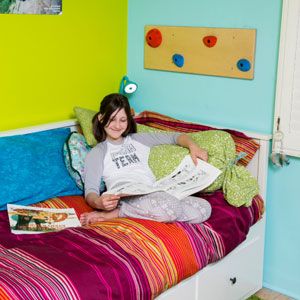 A girl reads on her bed.