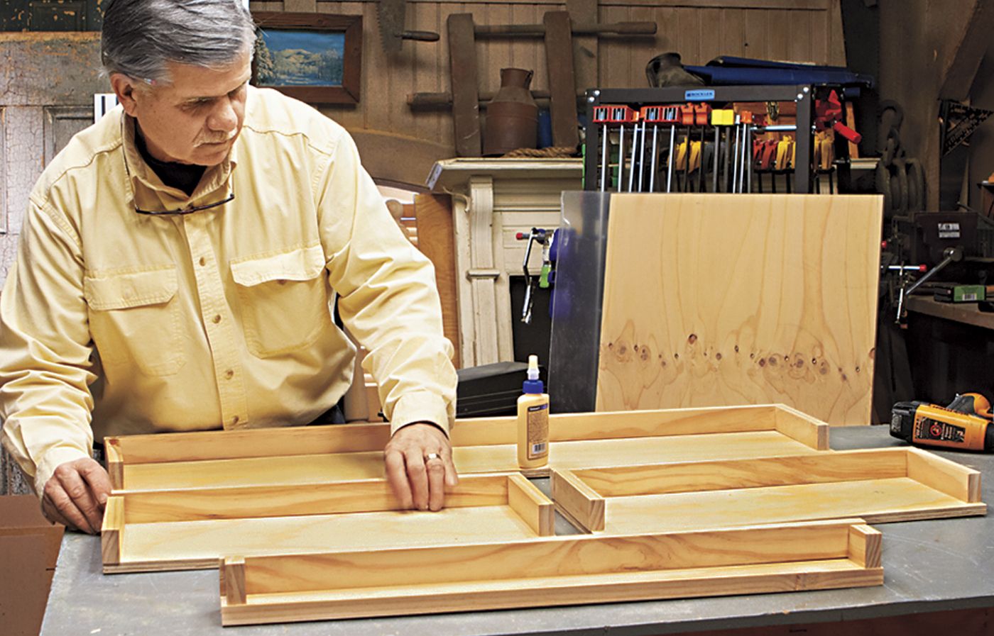 A man installing the cleats for a desk with a storage cubby.