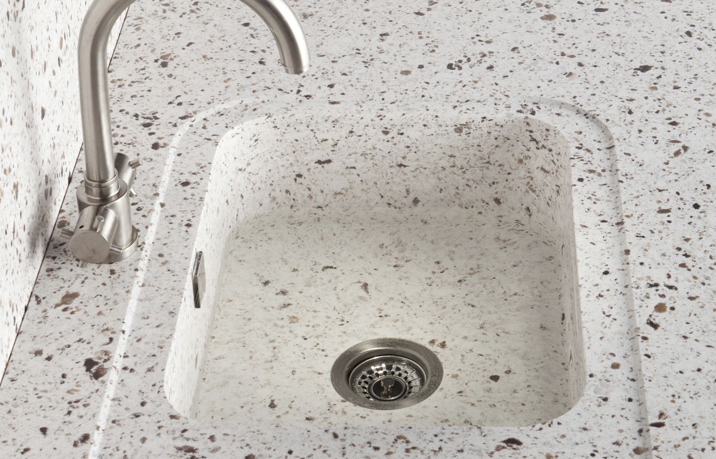 Image of a hidden-in-plain-sight kitchen sink that seamlessly blends into the countertop which is a great way to hide kitchen clutter