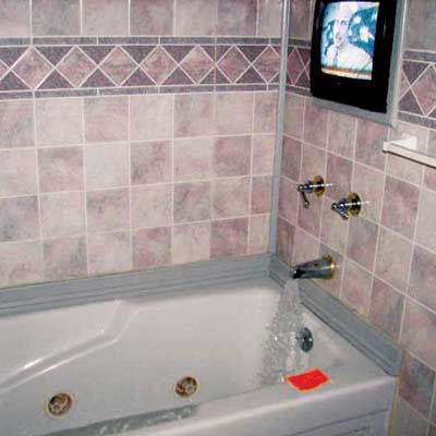 A tv above a bathtub, representing an electrical hazard