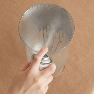 A layer of mercury colored paint being applied to a glass vase.