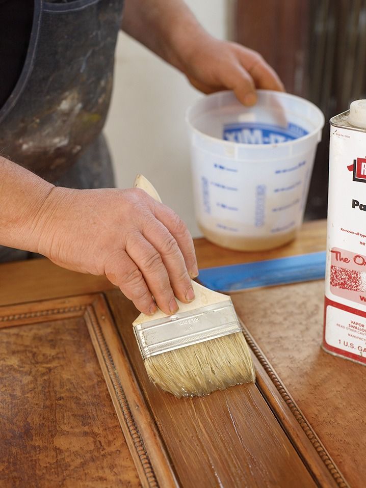 Stripping the old finish on a wooden door.