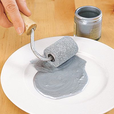 prepping the paint roller by rolling the paint on a plate