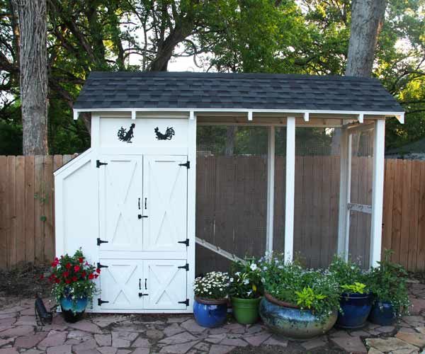 An elevated chicken coop in a yard.