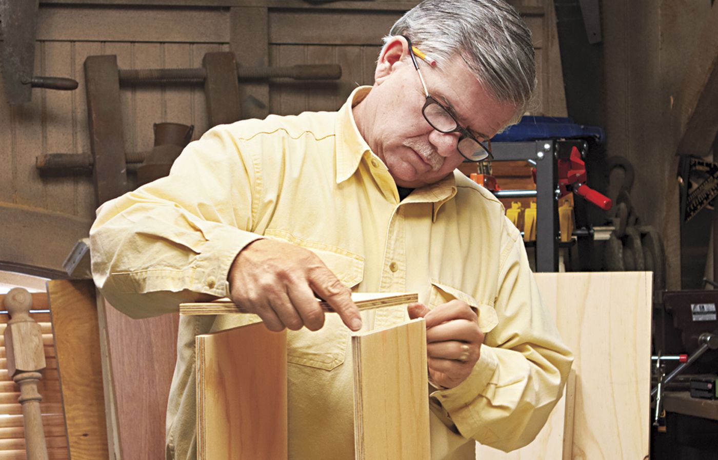 A man assembling the storage cubby for a desk.