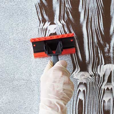 Image of a person using a wood graining rocker to create a faux wood grain effect. 