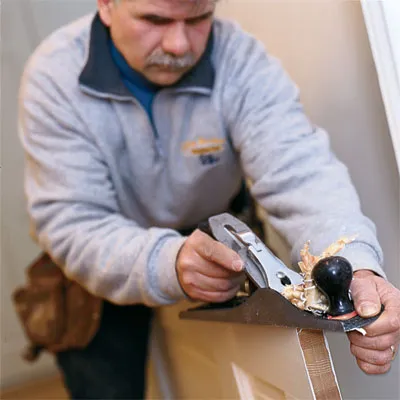 Tom Silva planes a door to stop it from sticking.