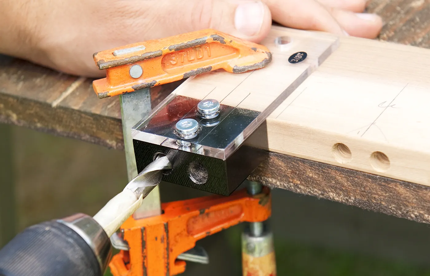 A person drilling holes for dowels and rods.