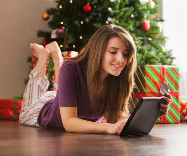 A woman sitting in front of a Christmas tree in a secure home.