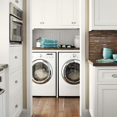 Man putting clothes in the washing machine, in the kitchen, worried because  he has to wash a lot of clothes. Close up Stock Photo - Alamy