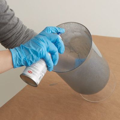 A second coating of mercury colored paint being applied to a glass vase.