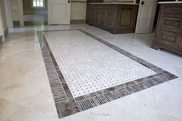 Tile rug with a multi-shape border using various shades which contrast one another. 